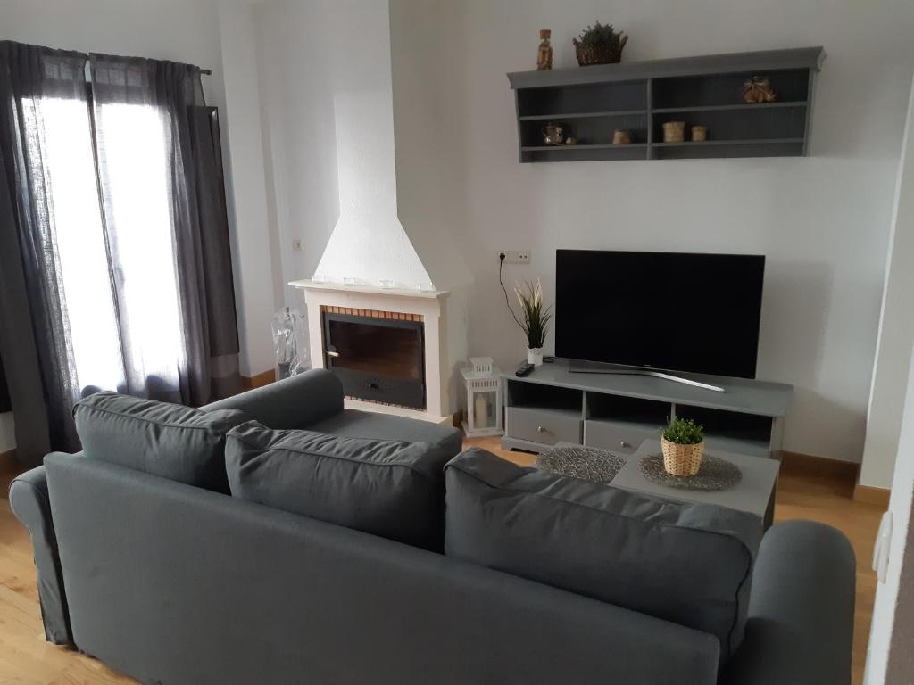 a living room with a couch and a television at Alojamiento La Fuente in Fuenteheridos