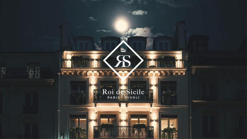 un cartel en la parte superior de un edificio por la noche en Roi de Sicile - Rivoli -- Luxury apartment hotel, en París