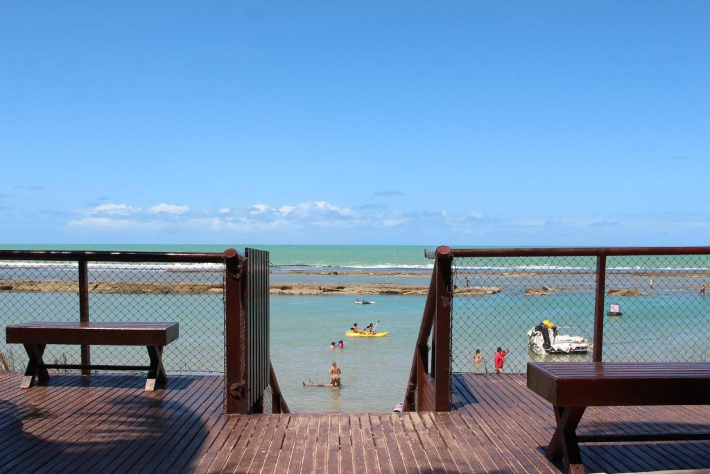 vistas a una playa con gente en el agua en Flats Nannai Residence Vilas, en Porto de Galinhas