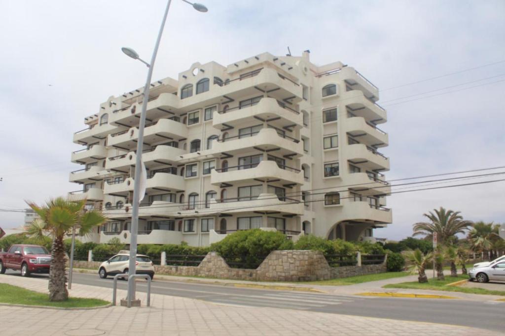 a large white building on the side of a street at Departamento frente al mar 4 personas, La Serena in La Serena