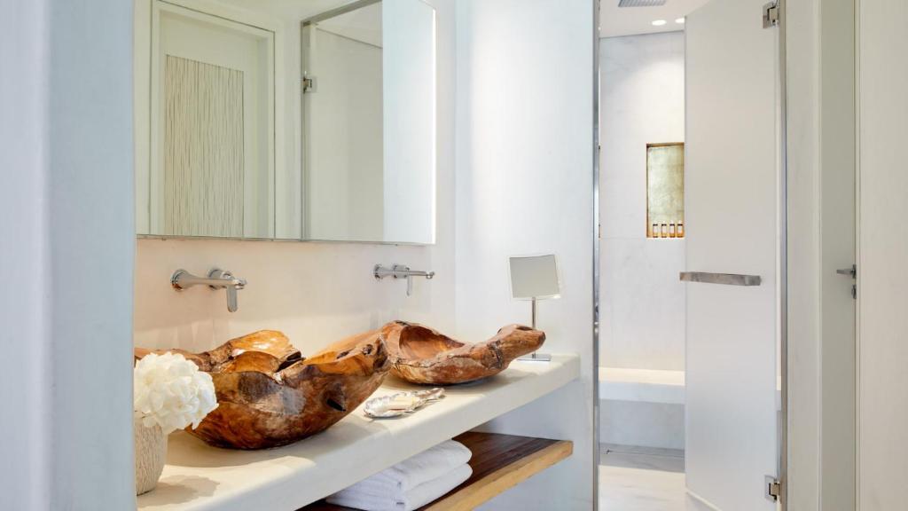 a bathroom with a sink and a mirror at Cavo Tagoo Mykonos in Mýkonos City