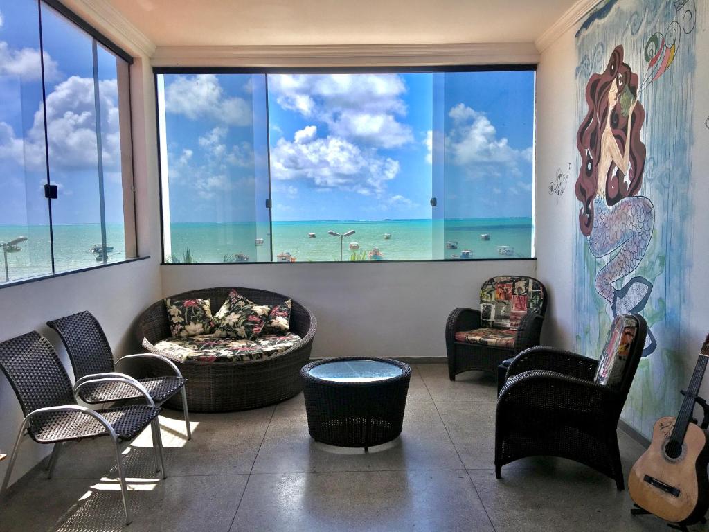 a living room with a large window with a view of the beach at Maraga Beach Hostel in Maragogi