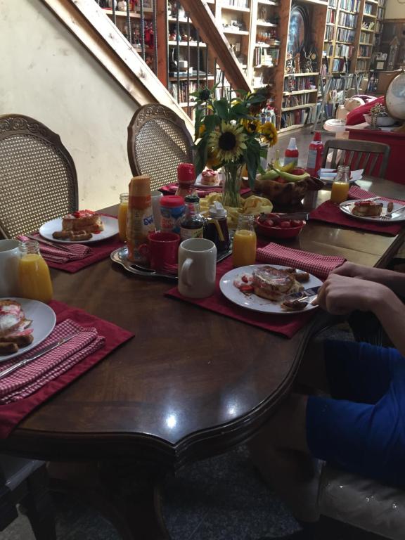 a wooden table with plates of food on it at The Old Church B&B in Warner