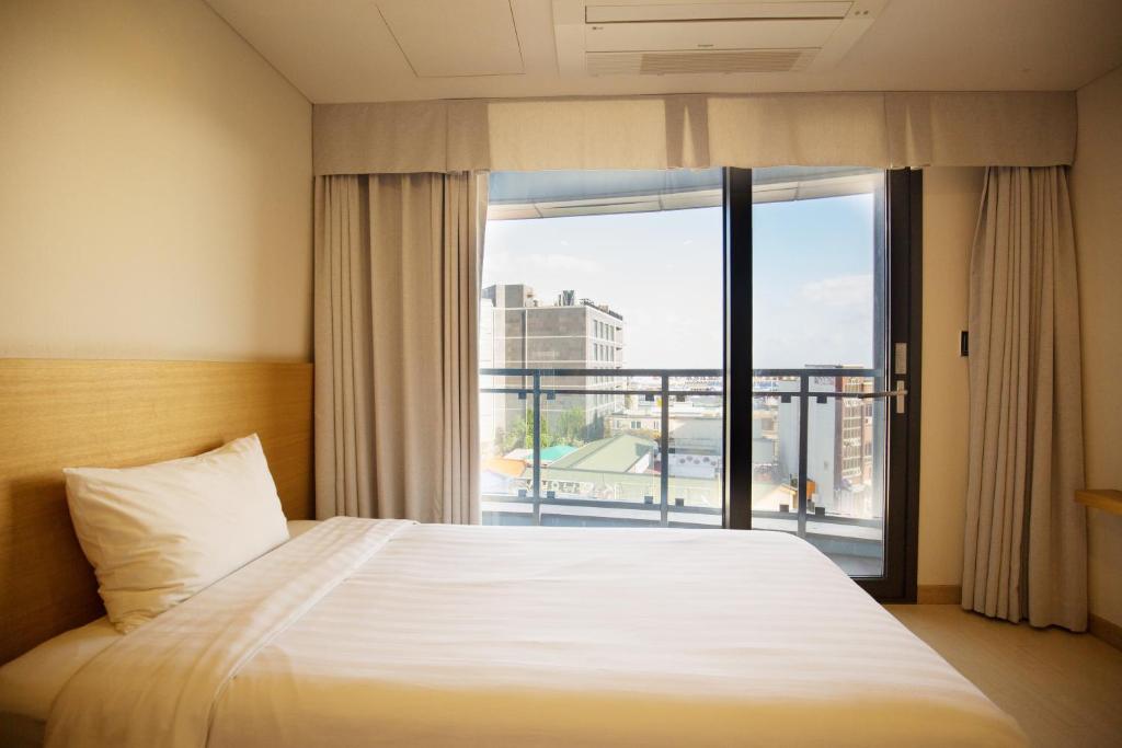 Postel nebo postele na pokoji v ubytování BK Hotel Jeju