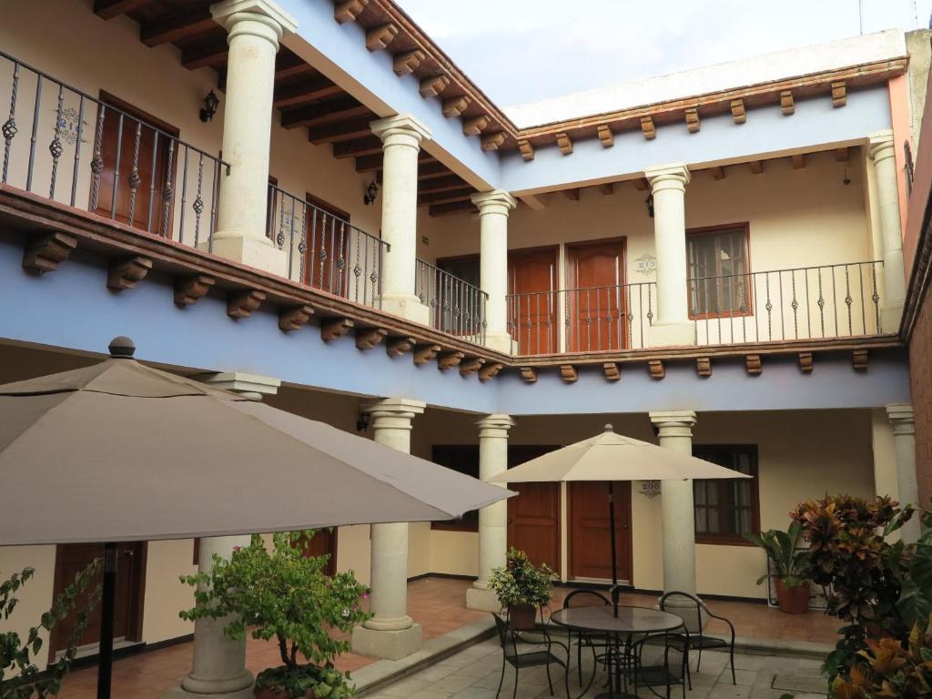 un patio con mesas y sombrillas en un edificio en HOTEL FERRI en Oaxaca de Juárez