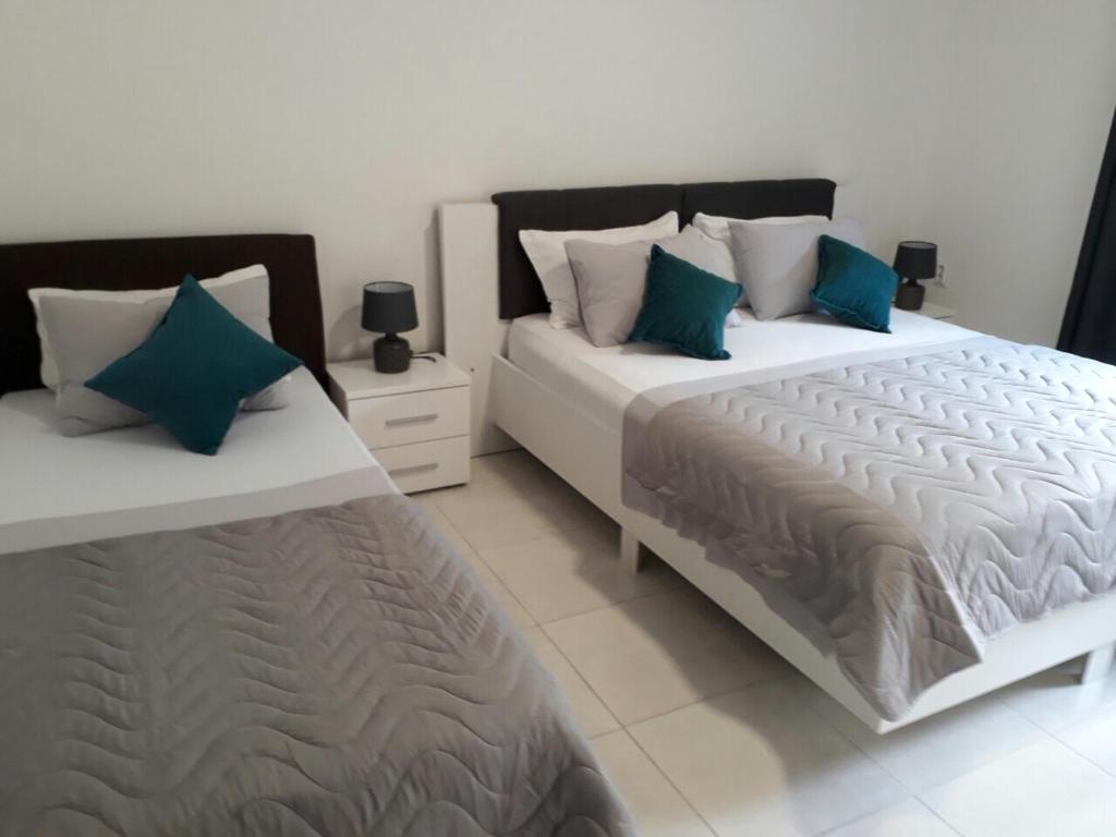 two beds sitting next to each other in a bedroom at Apartments Dionis in Kotor