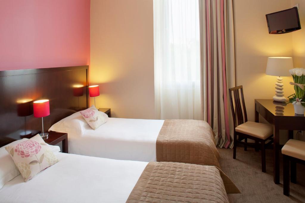 Postel nebo postele na pokoji v ubytování Hôtel Relais Acropolis