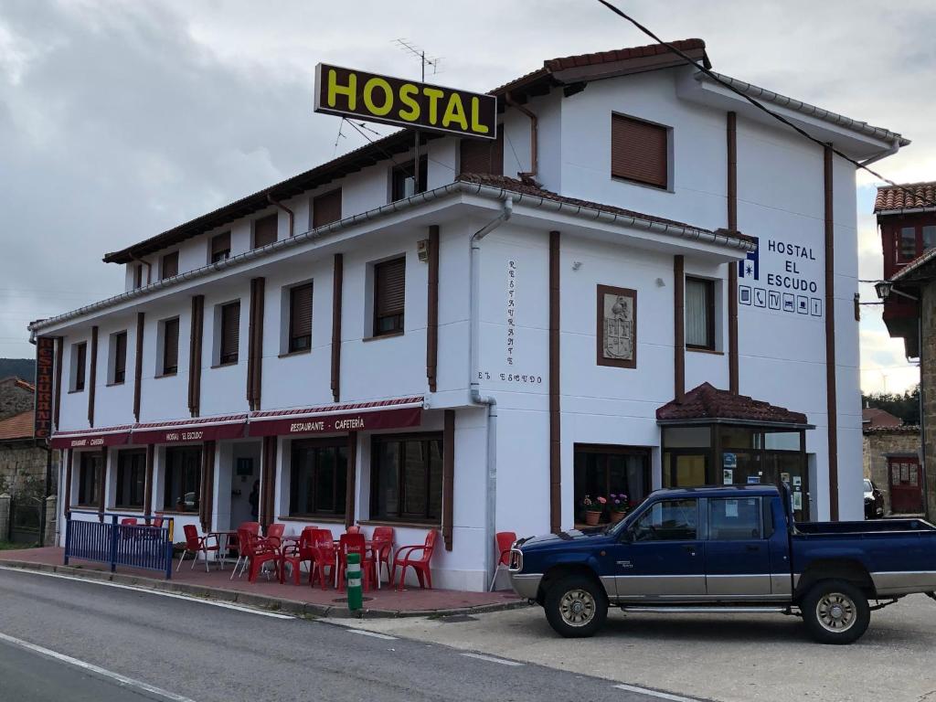 un camión azul estacionado frente a un hotel en HOSTAL EL ESCUDO, en Cilleruelo de Bezana