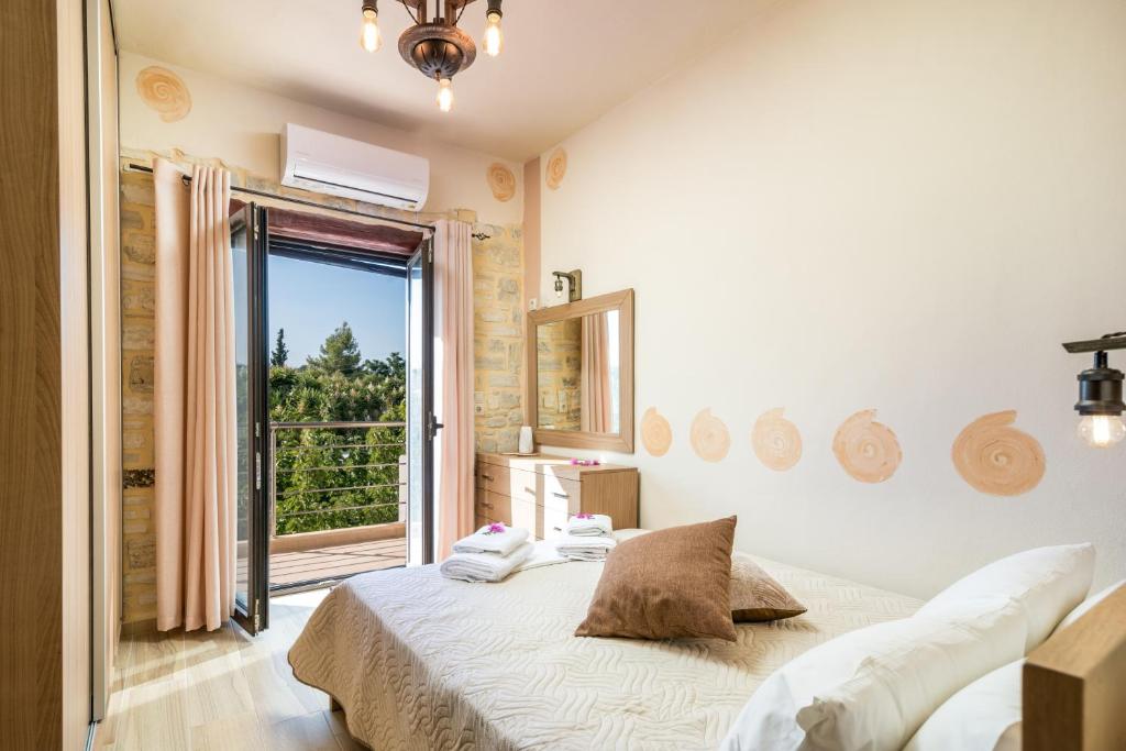 a bedroom with a bed and a large window at Ferienhaus Aretoussa in Pitsidia