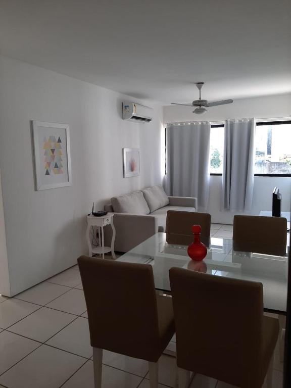 una sala de estar blanca con mesa y sillas en Park Way Home Service en Recife