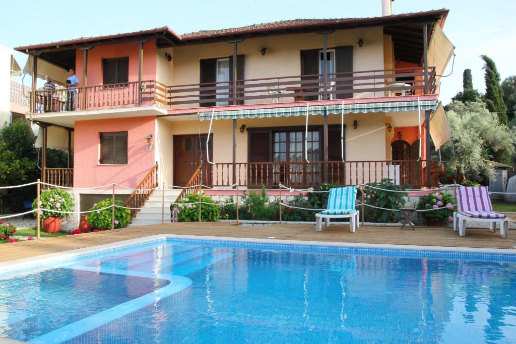 a villa with a swimming pool in front of a house at Villa Dimitra Nikiana in Nikiana
