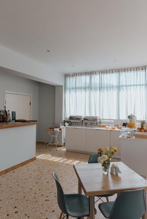 a room with a table and chairs and a kitchen at Vivari Acta in Vivari
