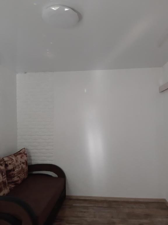 a white wall with a couch in a room at Новая квартира in Odesa