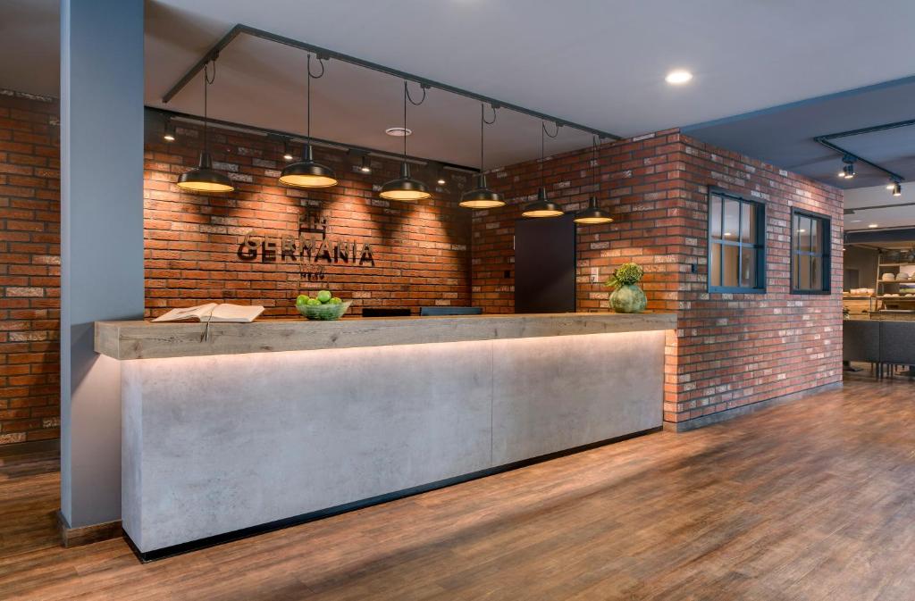 a lobby with a brick wall and a reception counter at GERMANIA Wissen in Wissen