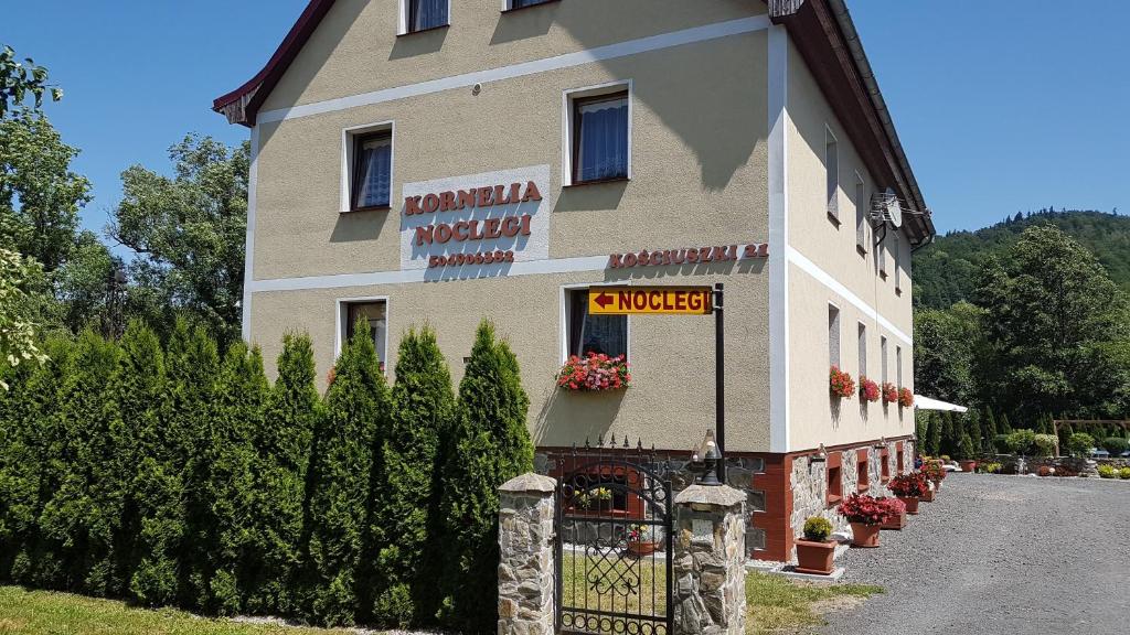 a building with a sign on the side of it at KORNELIA pokoje gościnne in Stronie Śląskie