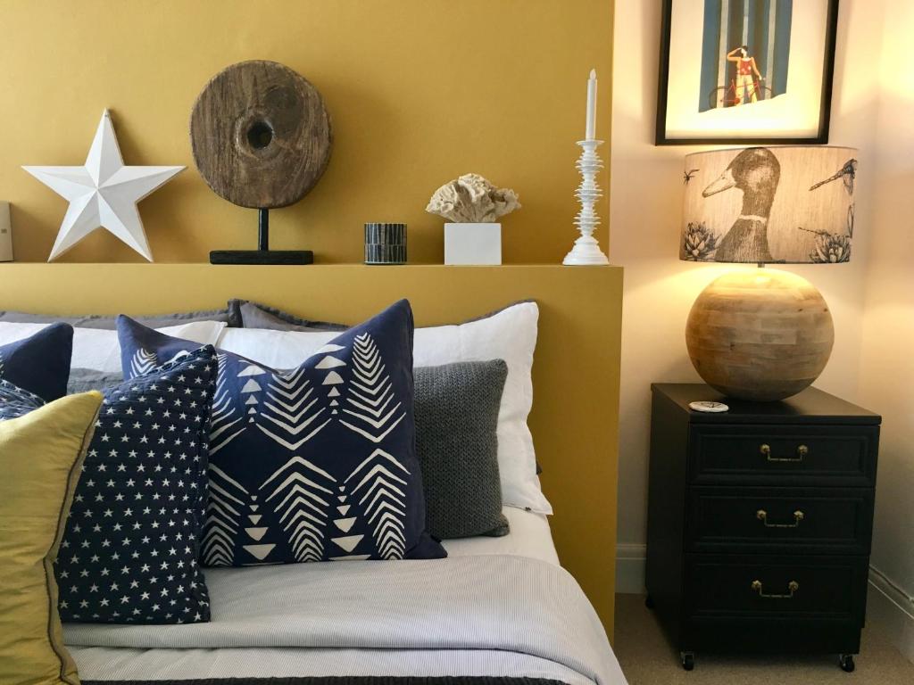 a bedroom with a bed with blue and white pillows at 'the inlet' falmouth in Falmouth