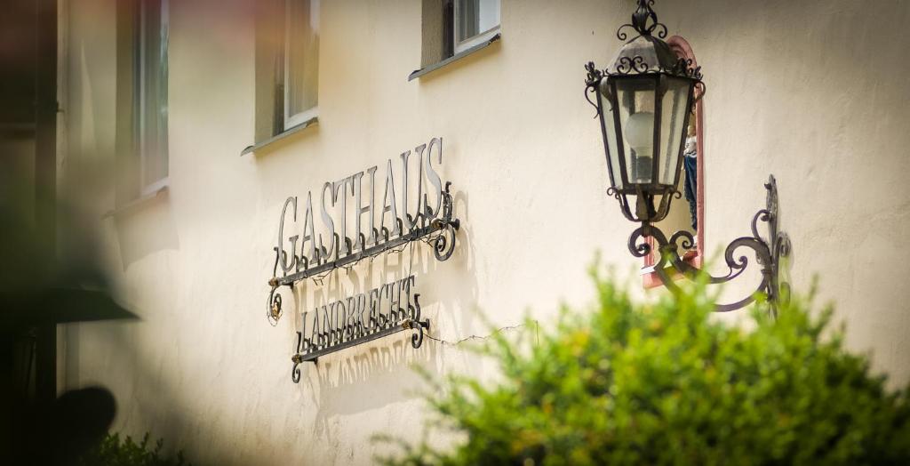 ein Schild an der Seite eines Gebäudes mit einer Lampe in der Unterkunft Gasthaus Landbrecht in Freising