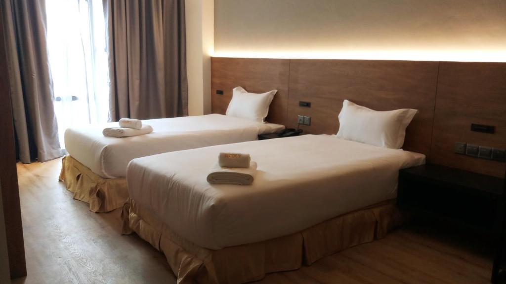 Postel nebo postele na pokoji v ubytování Roxy Hotel Padungan