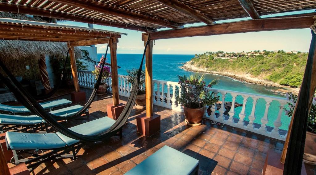 a porch with chairs and a view of the ocean at Villas Carrizalillo in Puerto Escondido