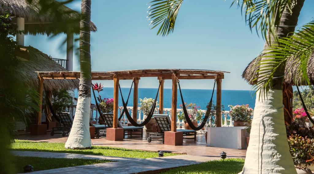a patio with a gazebo and the ocean at Villas Carrizalillo in Puerto Escondido