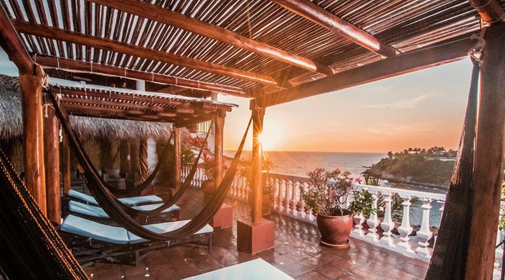 a porch with a hammock and a view of the ocean at Villas Carrizalillo in Puerto Escondido
