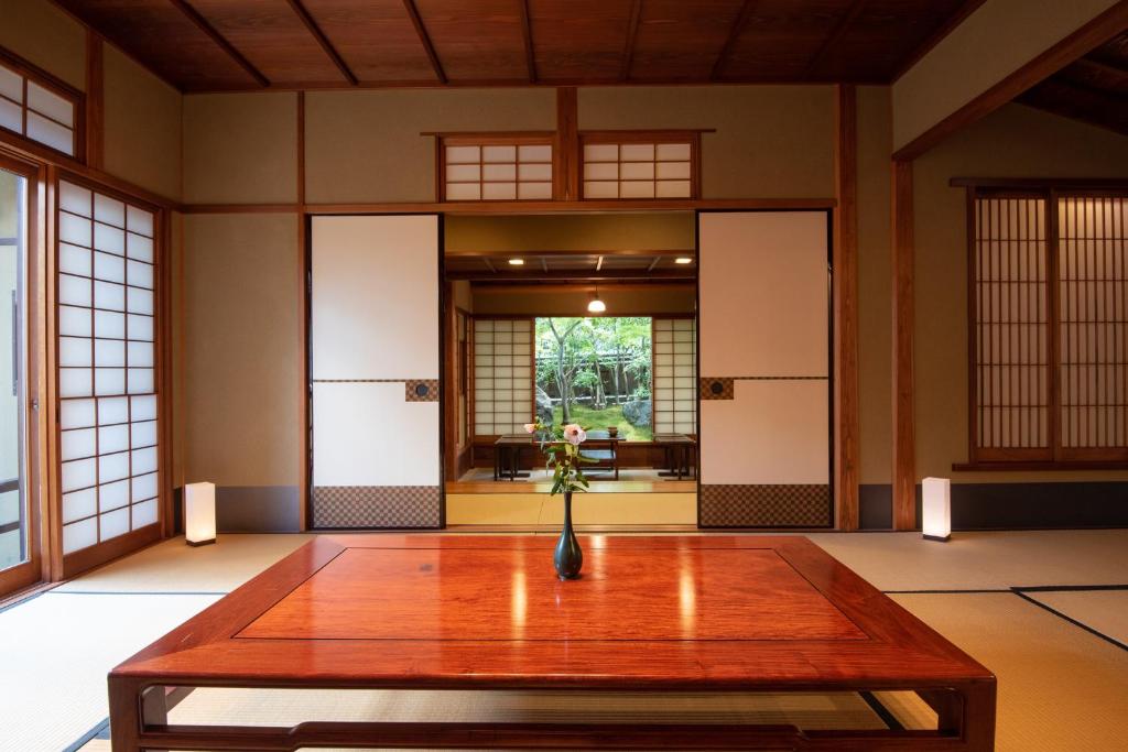 a room with a table with a vase of flowers on it at Nachiya in Kyoto