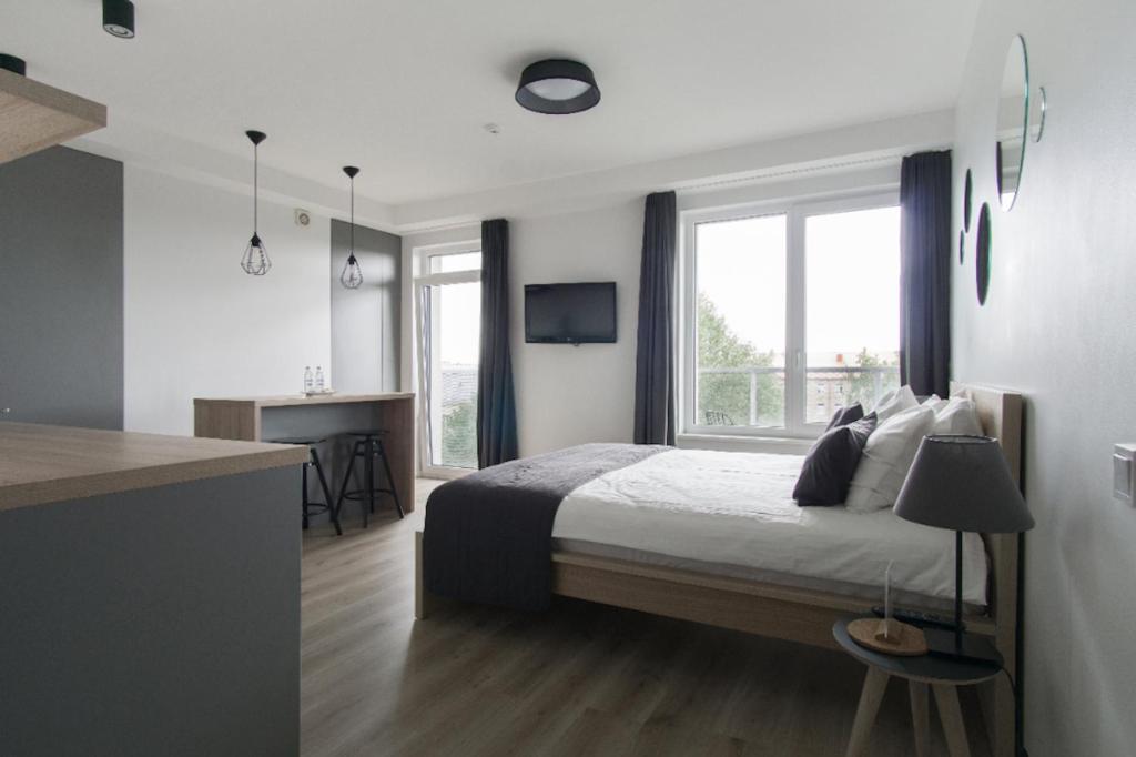 sypialnia z łóżkiem i dużym oknem w obiekcie Uptown studio apartment w Wilnie