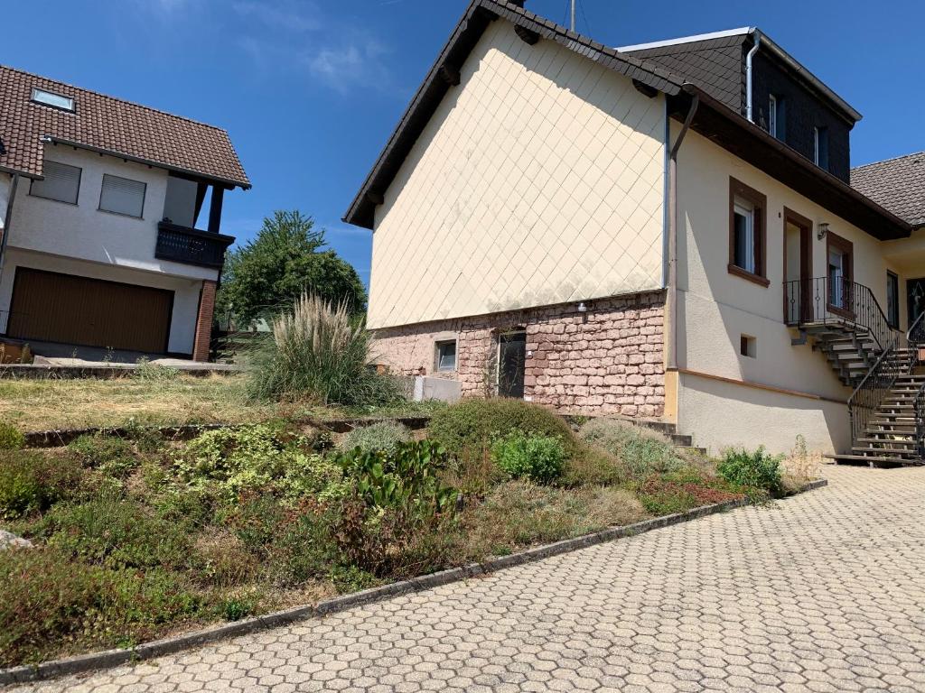 ein Haus mit einem gemauerten Bürgersteig neben einem Gebäude in der Unterkunft Home Feeling trierweiler in Trier