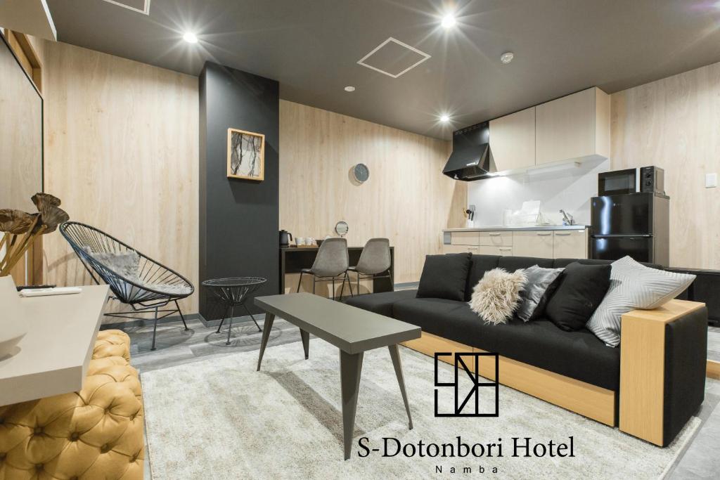 een woonkamer met een bank en een keuken bij S-Dotonbori Hotel Namba - Self Check-In Only in Osaka