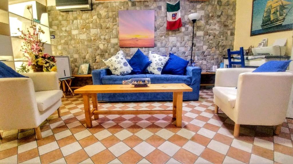 a living room with a blue couch and two chairs at Marinautica Sea Cottage in Sorrento