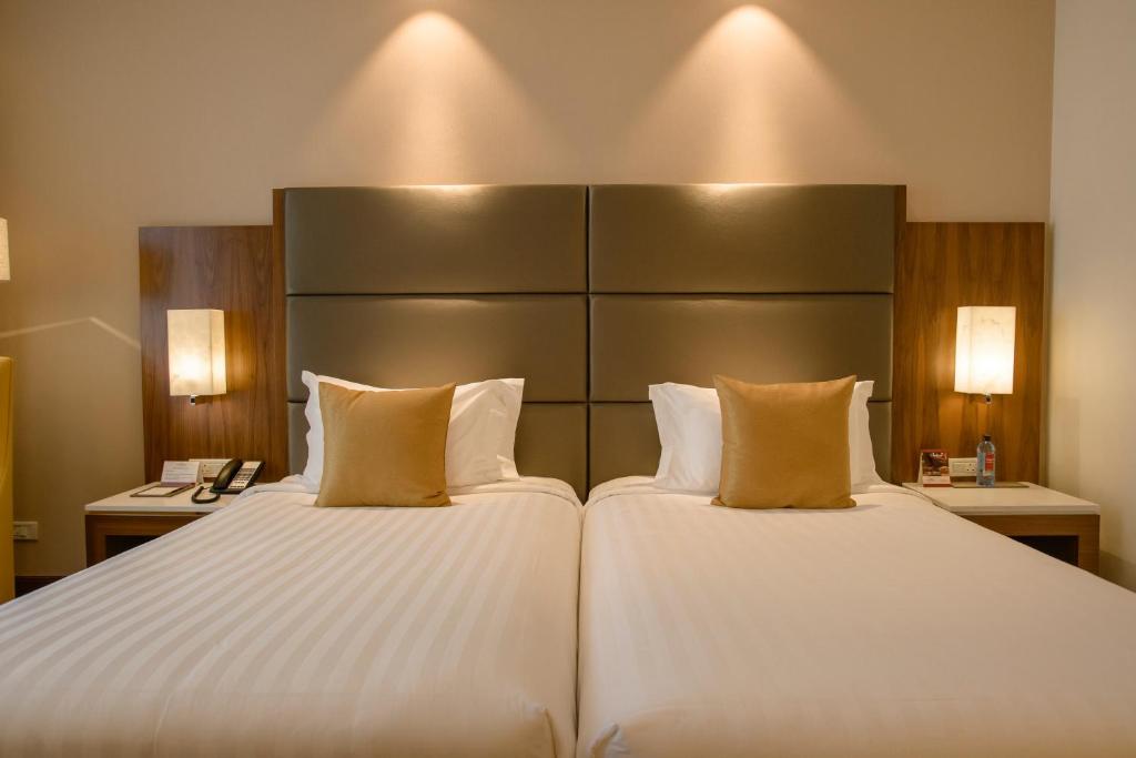 a hotel room with two beds and two lamps at Crowne Plaza Nairobi Airport by IHG in Nairobi