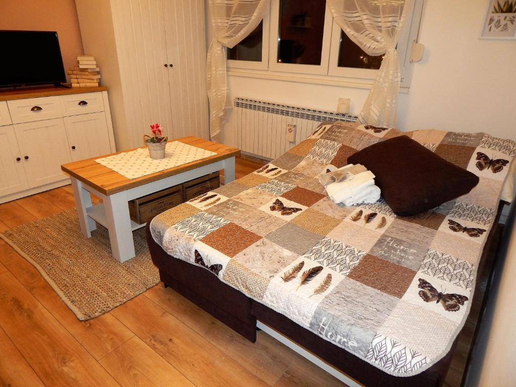 a bedroom with a bed with a table and a bed sidx sidx sidx at Studio APARTMAN TVRTKO in Varaždin