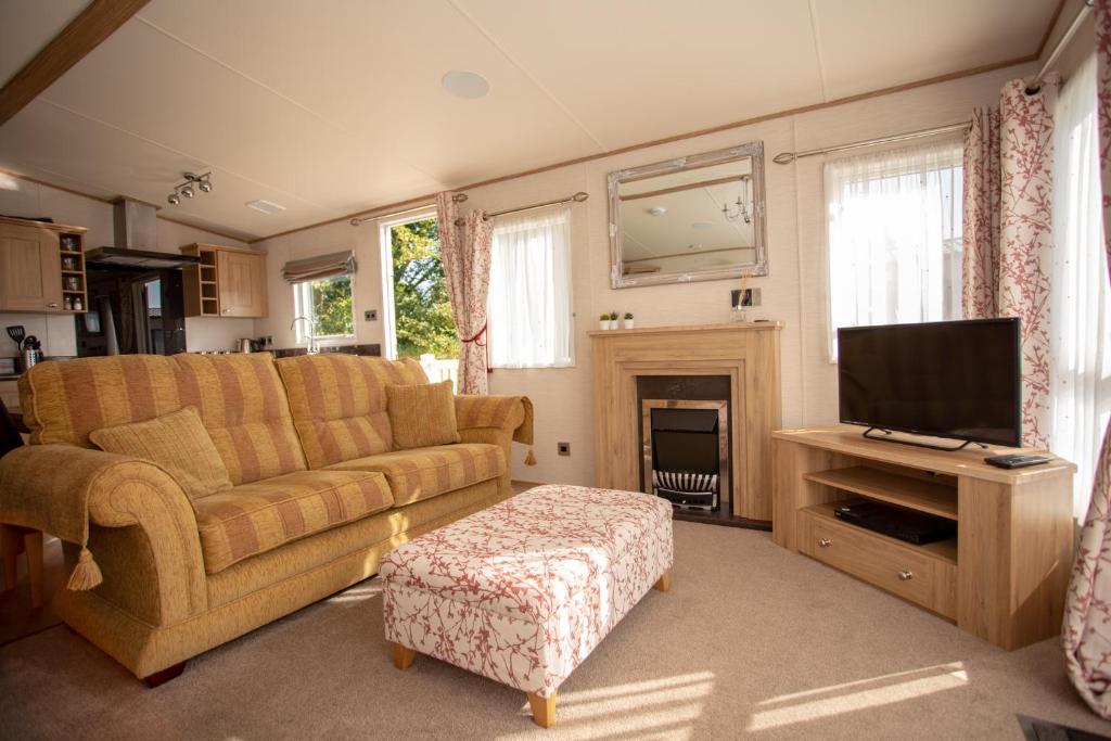 a living room with a couch and a television at Robin's Retreat in South Cerney