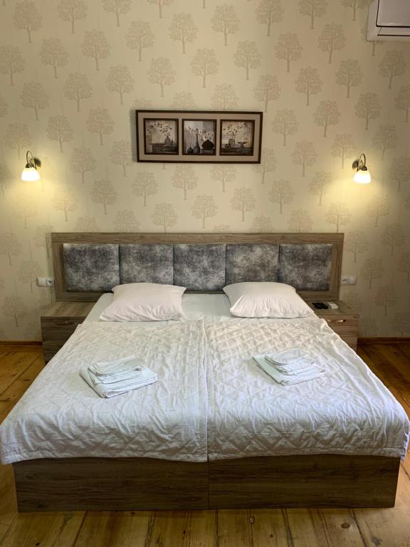 ein Schlafzimmer mit einem großen Bett mit zwei Handtüchern darauf in der Unterkunft Guest House Rafael in Tbilisi City