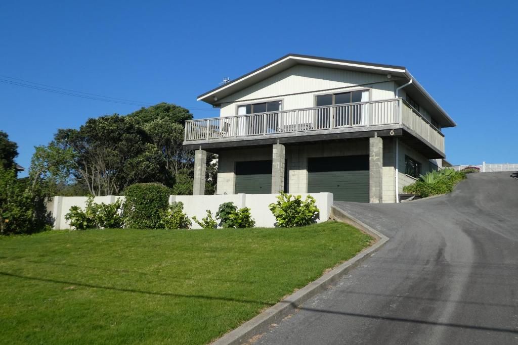 a house on a hill with a driveway at Olde Beach Villa in Waikanae