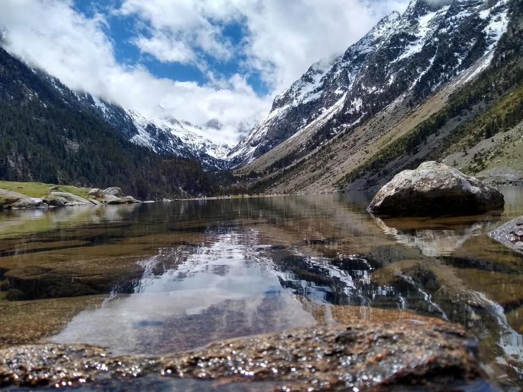 a mountain reflecting in the water of a lake at T2 RESIDENCE 3 ETOILES Piscine chauffée Sauna Hammam in Cauterets