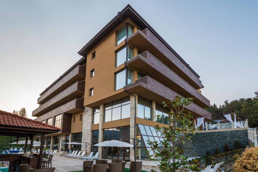 un bâtiment avec des chaises et des tables devant lui dans l'établissement Katalina SPA Resort, à Tsigov Chark