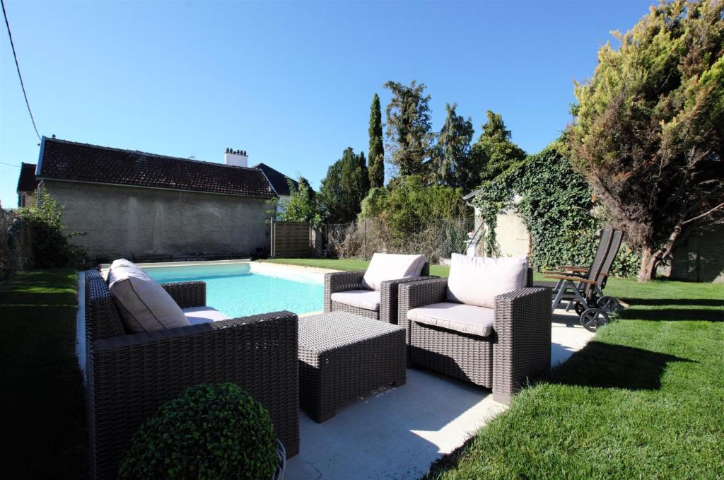 un grupo de sillas y una piscina en A L'Aube de Troyes, en Sainte-Savine