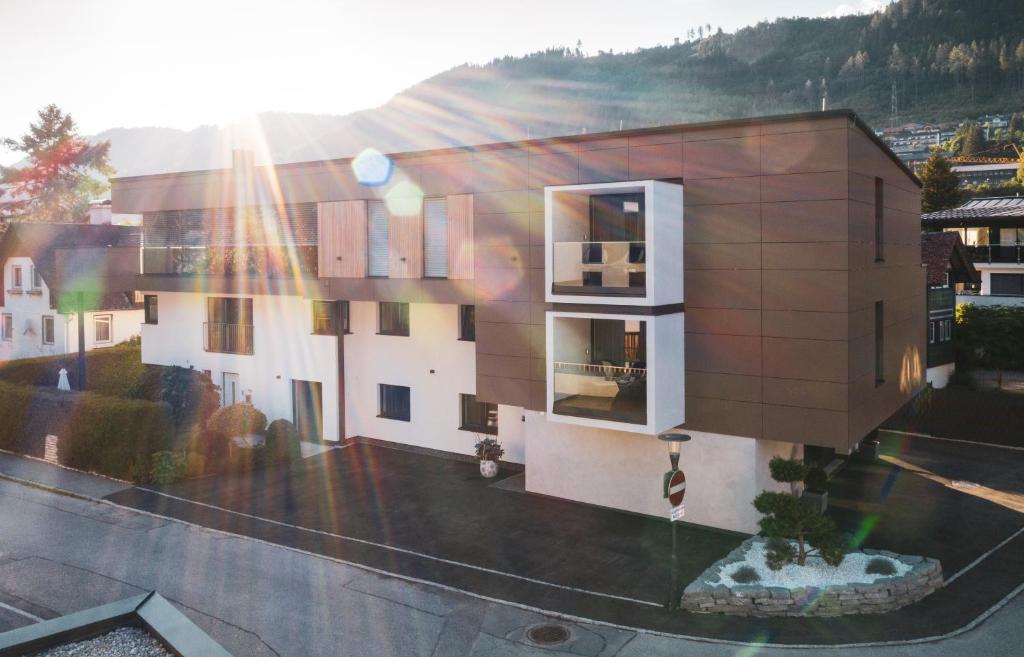 a rendering of a building with the sun shining on it at ImPuls | aparts in Schladming