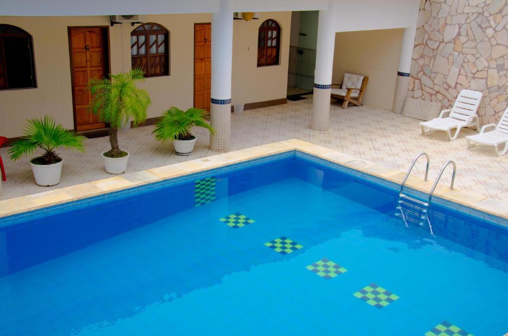 a large swimming pool with blue water in a house at Pousada Novo Tempo in Lauro de Freitas
