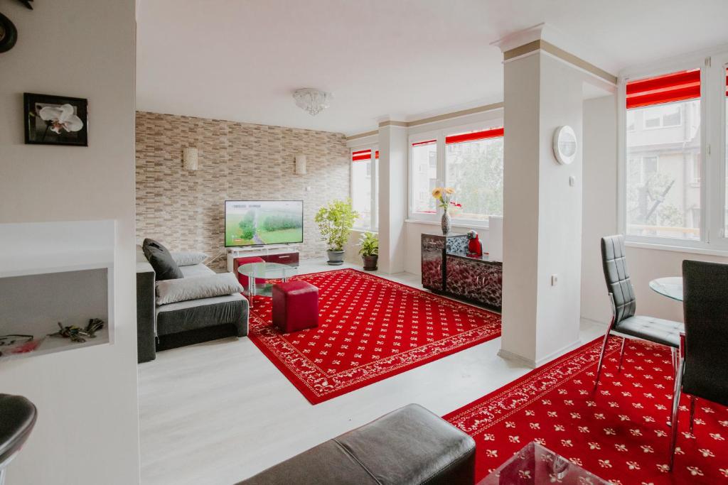 a living room with a red rug at Dimitrovi Rooms in Sofia