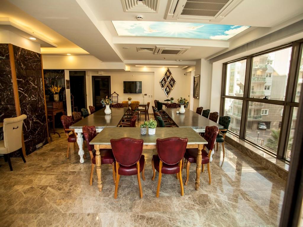 a dining room with a large table and chairs at Lion Park Suites & Residence Hotel in Aydın