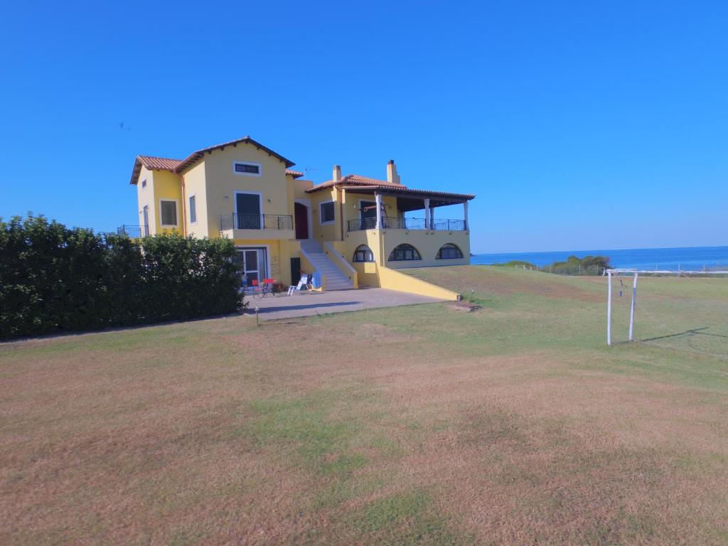 ein Haus auf einem Hügel mit dem Ozean im Hintergrund in der Unterkunft Sea Breeze ena in Korakokhórion