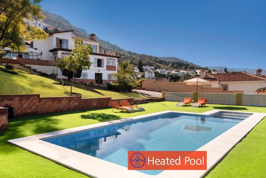 uma villa com uma piscina aquecida e um quintal em Villa Peralta em Alhaurín de la Torre
