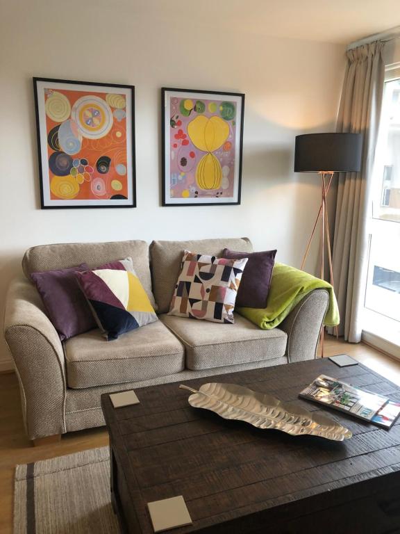 a living room with a couch and paintings on the wall at Hansen House 2 with Private Parking in Cardiff