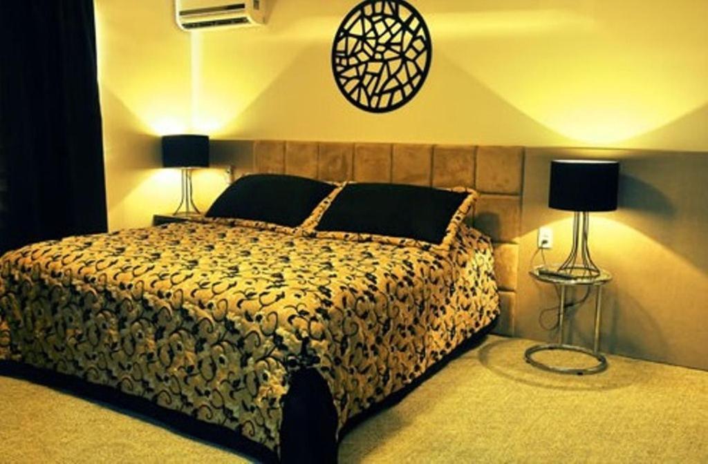 1 dormitorio con 1 cama con 2 lámparas en Petry Plaza Hotel, en Canoinhas