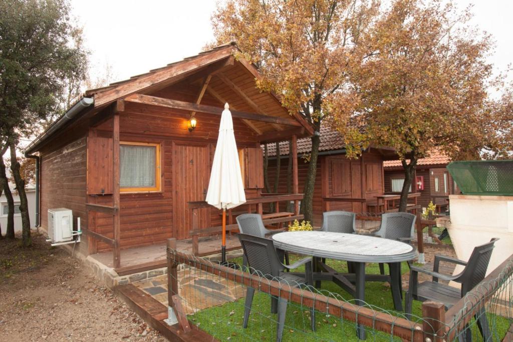 a cabin with a table and chairs and an umbrella at Camping Gironella in Gironella