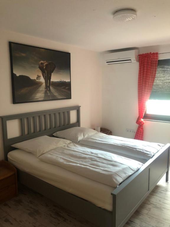 a bed in a bedroom with a picture of an elephant at Wohnen auf Zeit in Duisburg