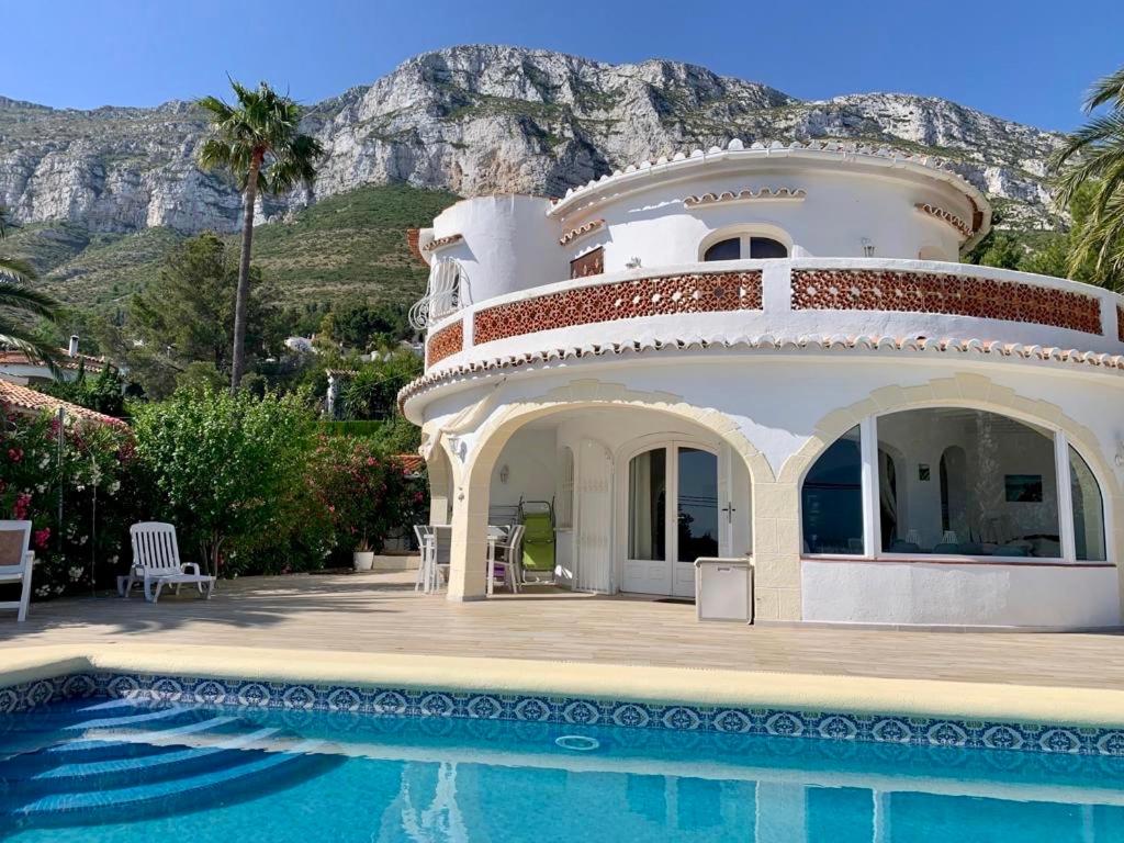 a house with a swimming pool next to a mountain at Villa Denia Costa Blanca in Denia