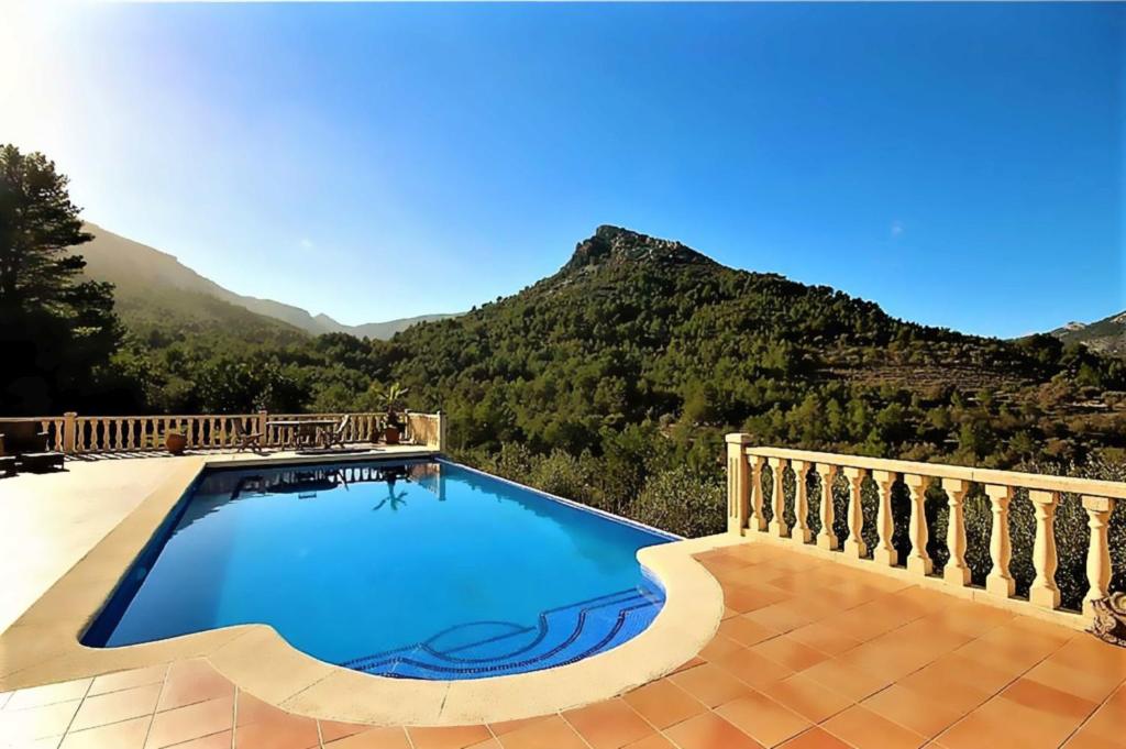 una piscina con montañas en el fondo en Villa Foia Vella - adults only, en Benichembla